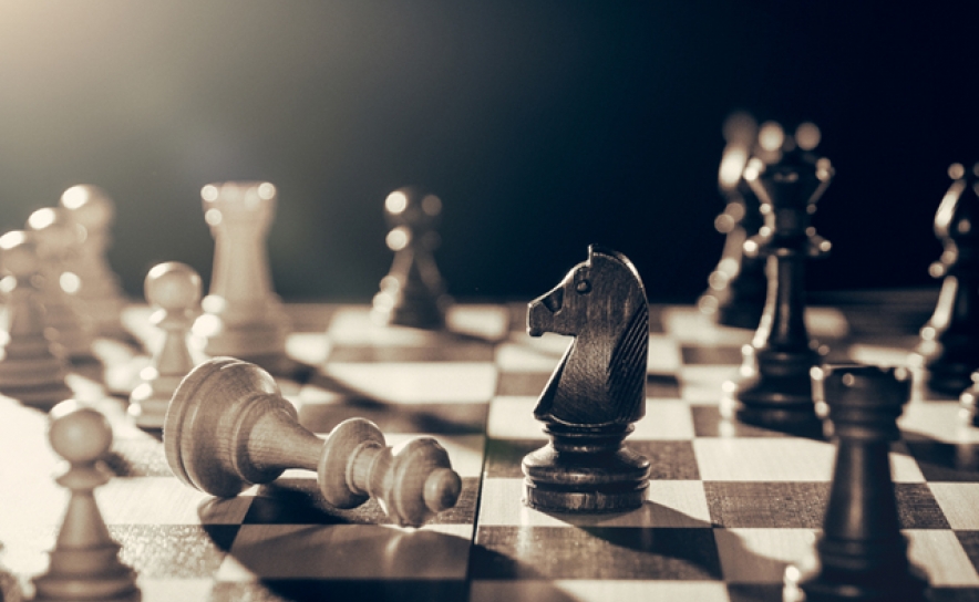 Um jogo de xadrez com um rei em pé na frente de um lance de